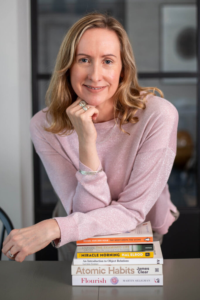 Business coach smiling with books during brand shoot
